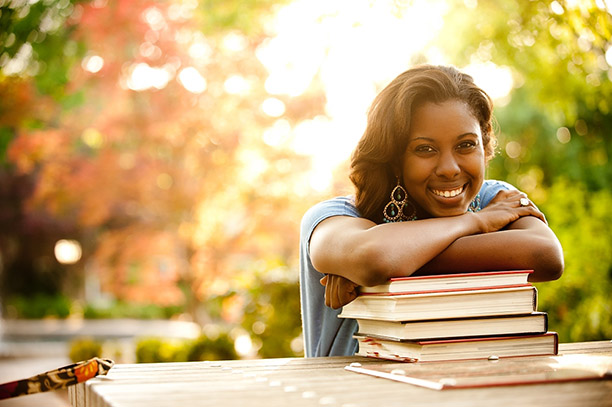 UGA student sits with books at a table on campus